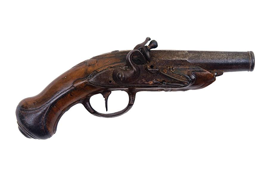 Flintlock pistol with a short, wide barrel and a wooden handle featuring a curved grip. The metal parts show signs of aging and rust, and the wooden stock has a dark, polished finish with some wear. The pistol has a traditional flintlock mechanism.